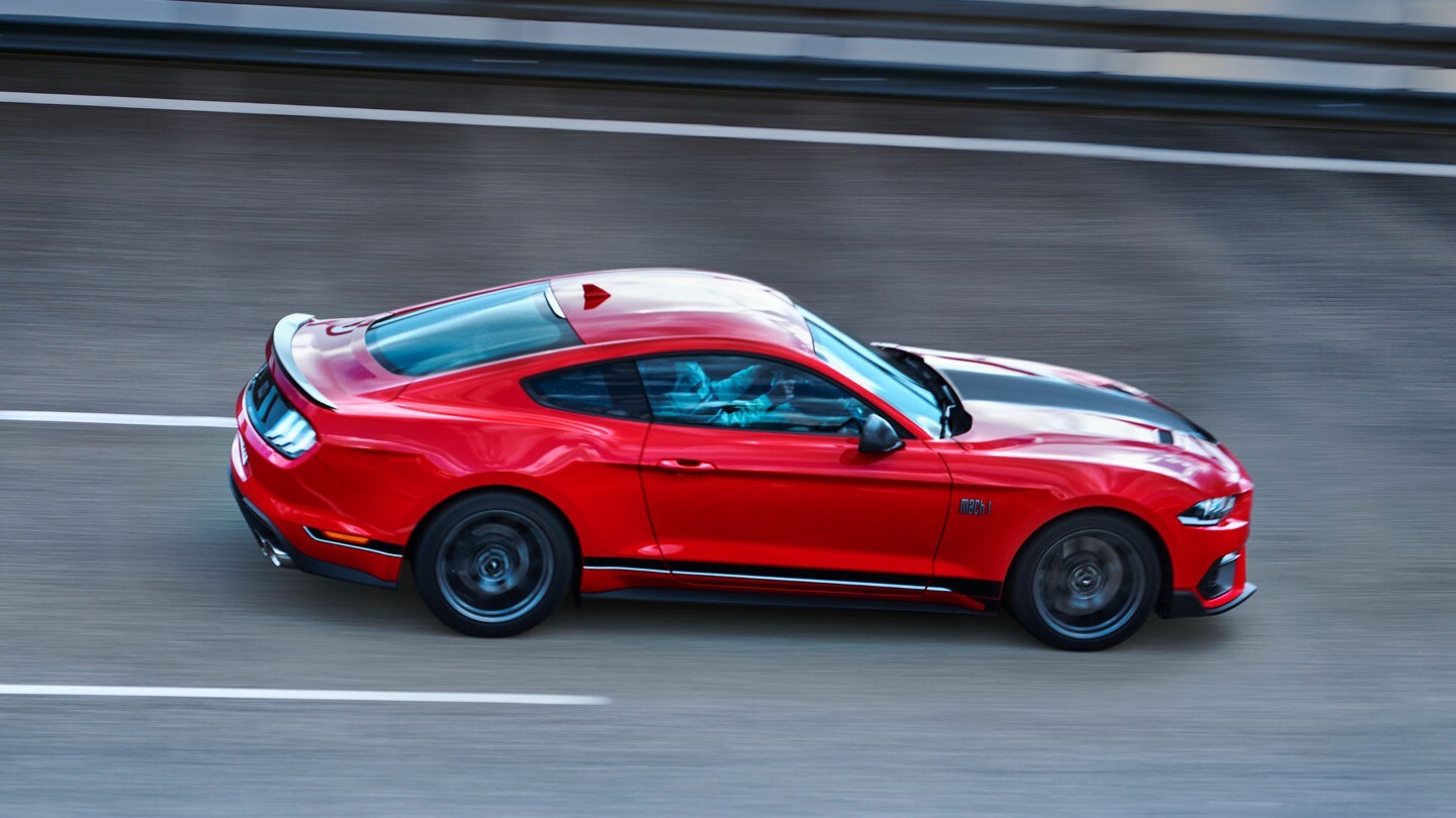 Ford Mach 1 in Rot. Seitenansicht, auf Straße fahrend