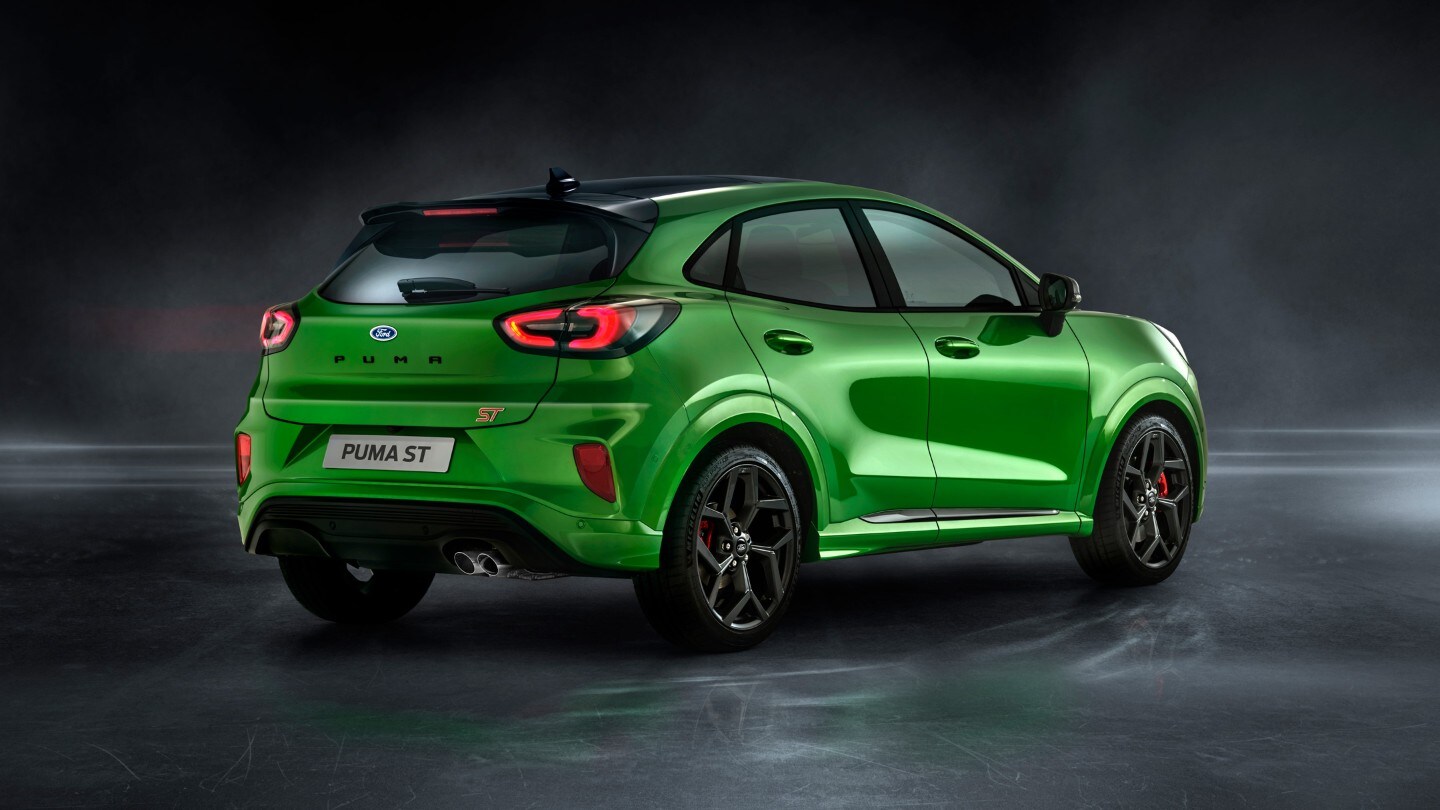 Ford Puma ST in Grün. Dreiviertel-Heckansicht, stehend in einem dunklen Showroom
