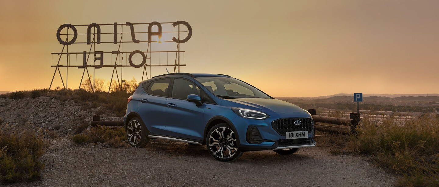 Ford Fiesta in Blau. Dreiviertelansicht, in der Natur parkend mit Sonnenuntergang. 