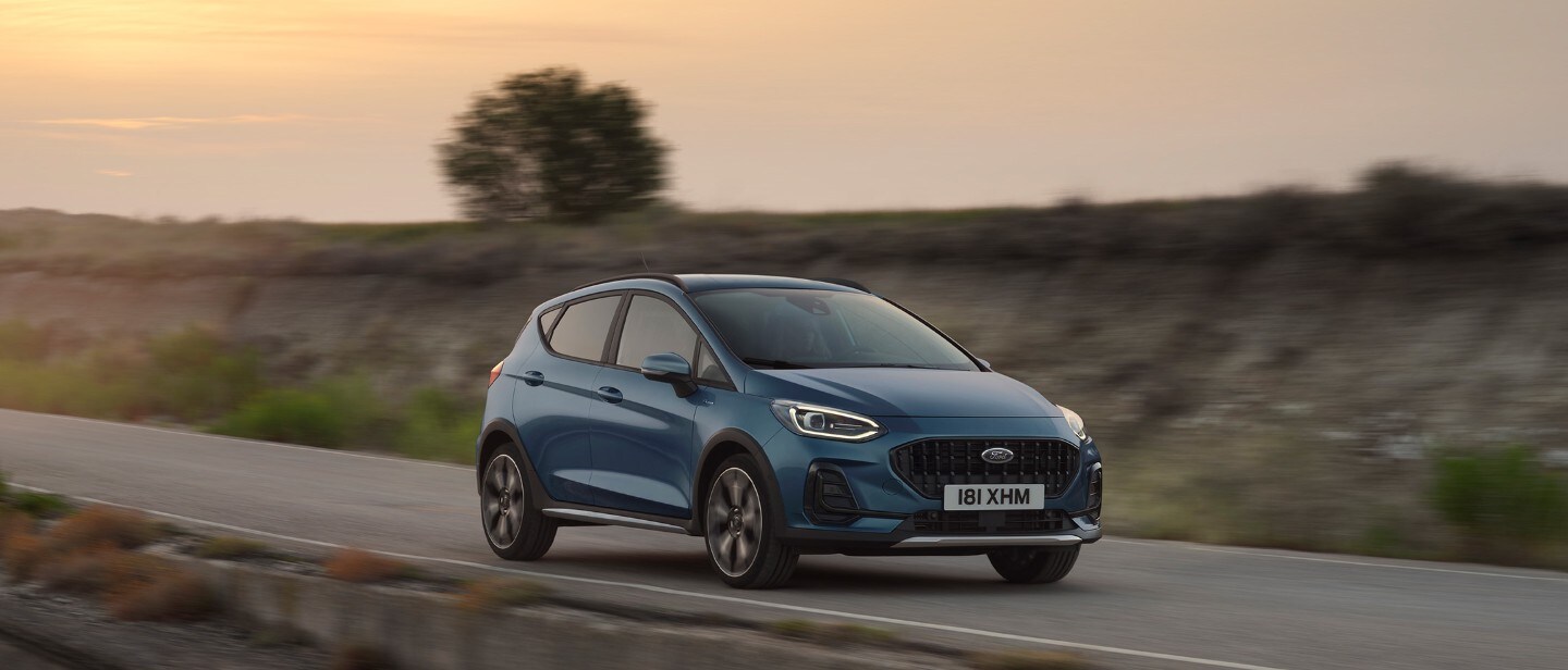 Ford Fiesta in Blau. Dreiviertelansicht, fährt in einer ländlichen Umgebung