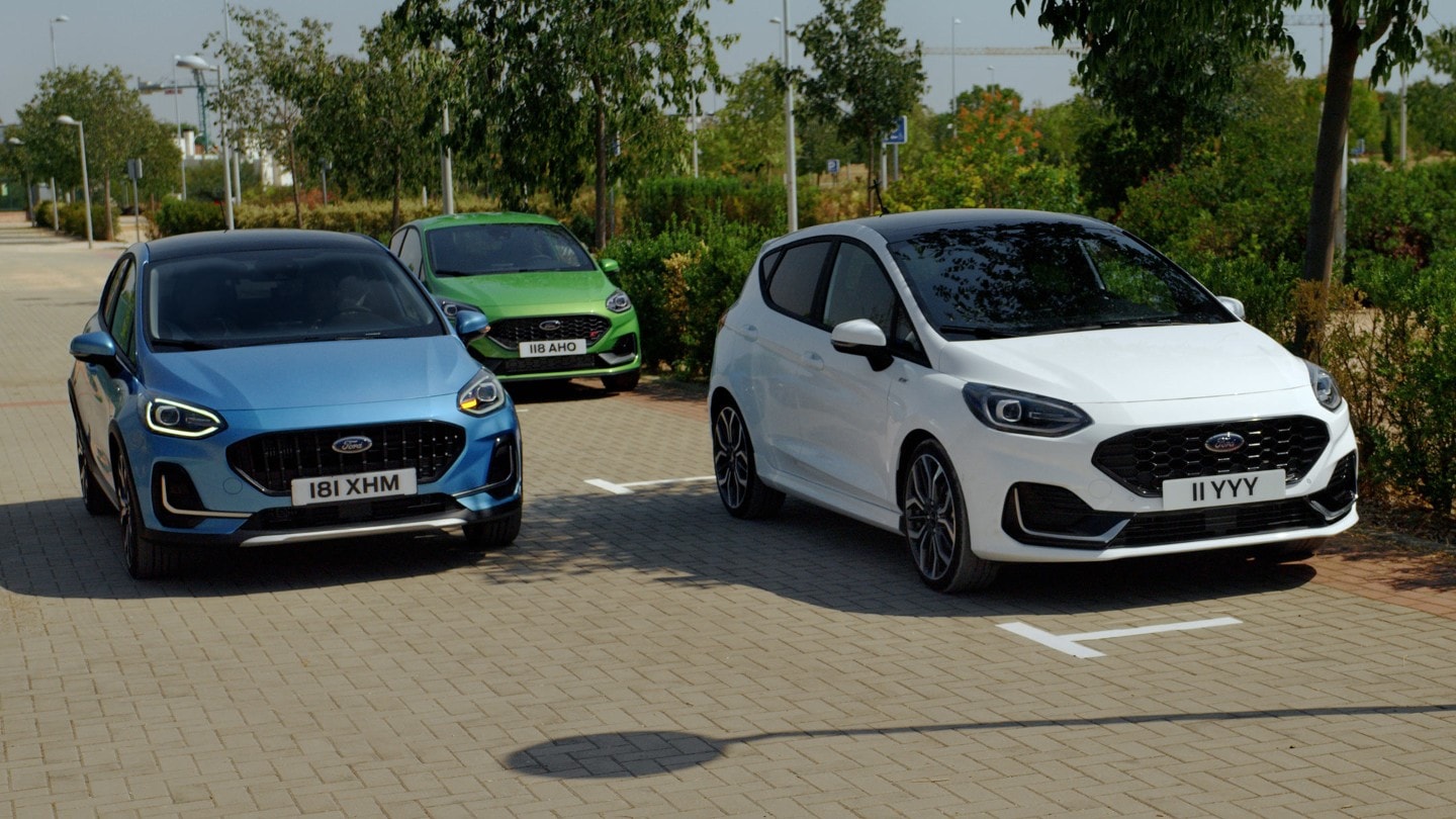 Ford Fiesta in Weiß und Blau. Frontansicht, auf einem Parkplatz mit Visualisierung aktiver Park-Assistent