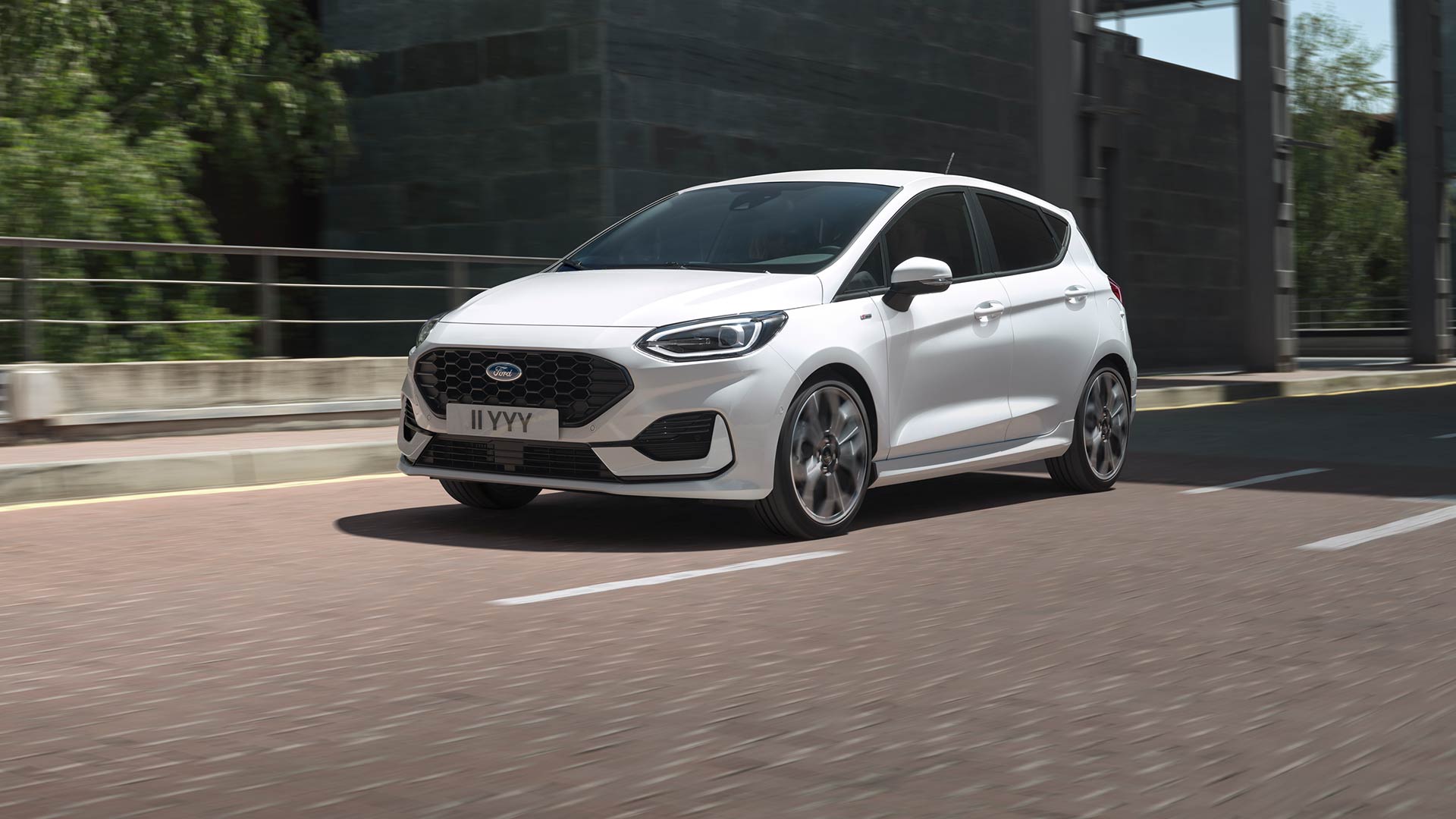 Ford Fiesta in Weiß in einer dynamischen Fahrszene auf einer Straße.