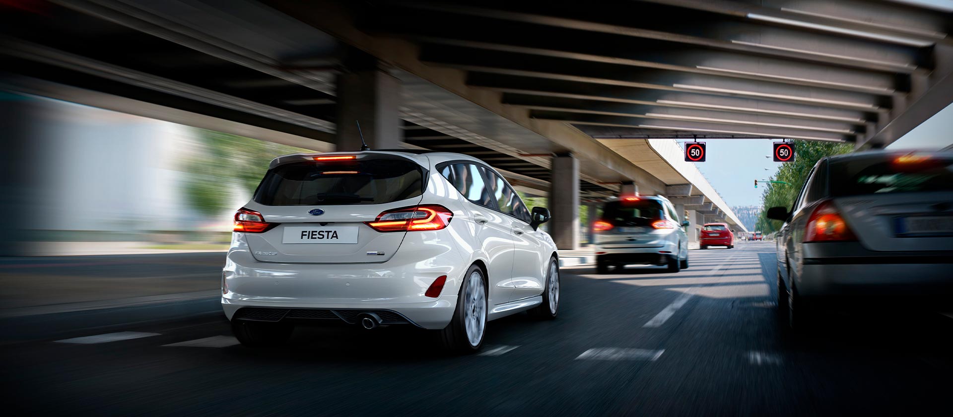 Ford Fiesta in Weiß. Heckansicht, fährt auf einer Autobahn.