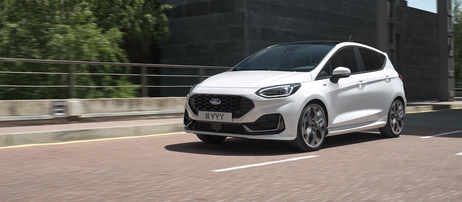 Ford Fiesta in Weiß. Dreiviertelansicht, fährt auf der Straße.