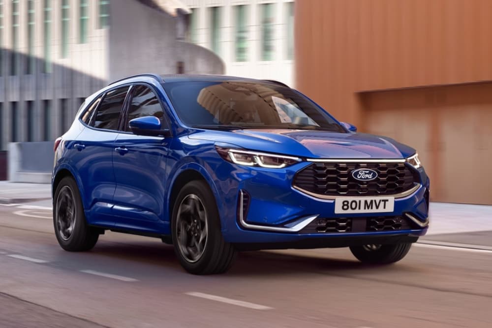Ford Kuga in Blau. Dreiviertelansicht, fahrend auf einer Straße.
