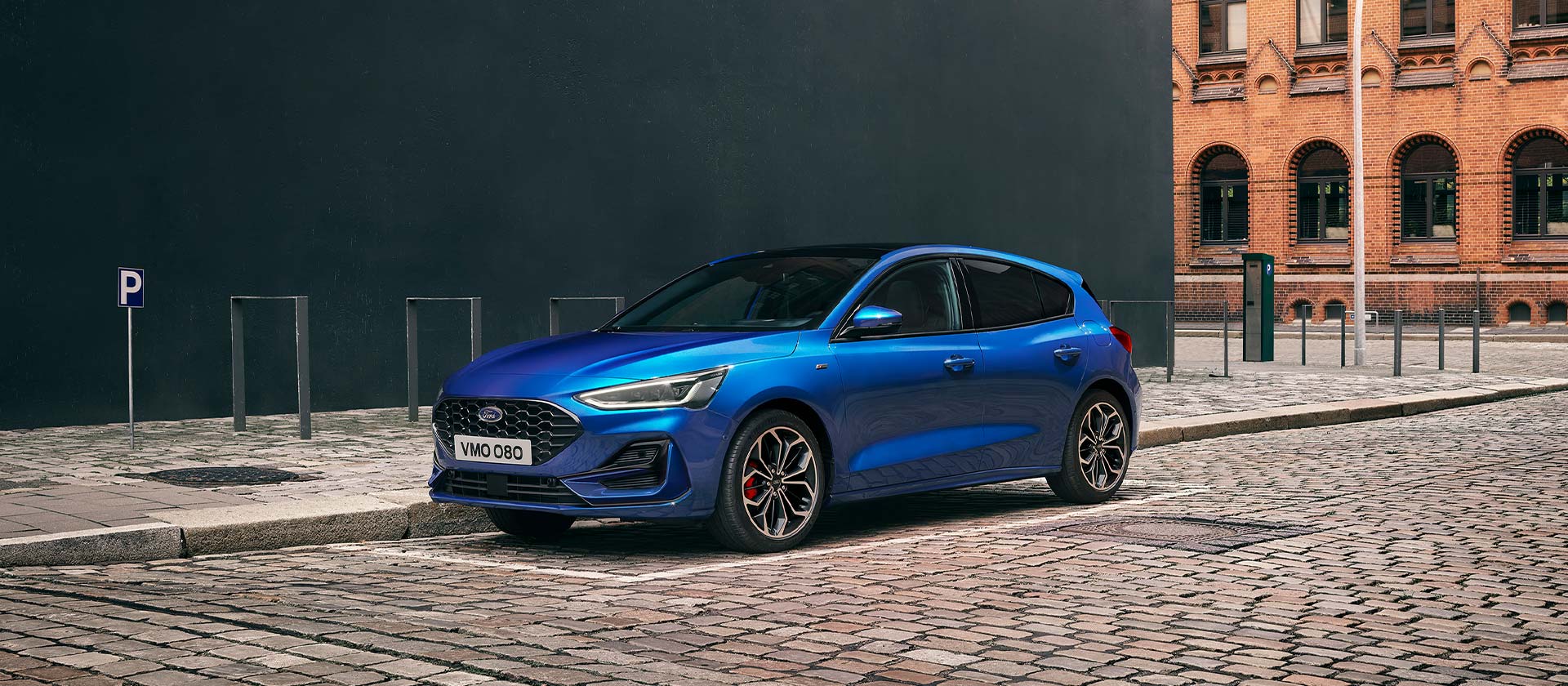 Ford Focus ST-Line in Blau. Seitenansicht, in einer industriellen Gegend parkend.