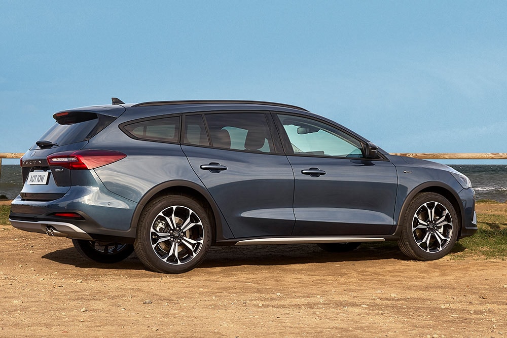 Ford Focus Active in Blau. Seitenansicht, neben einem See parkend.