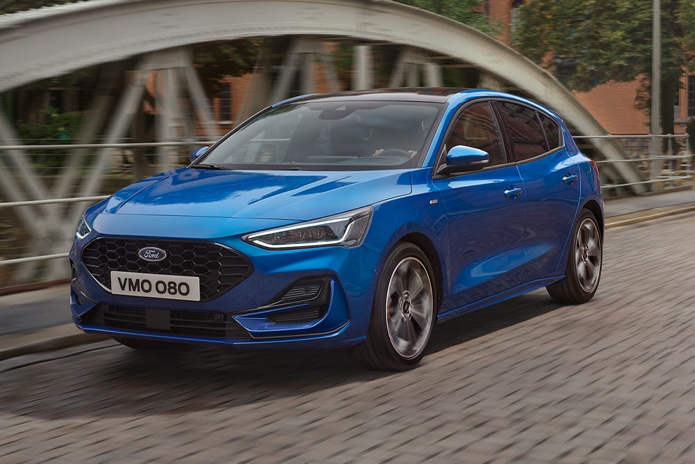 Ford Focus ST-Line in Blau. Dreiviertelansicht, über eine Brücke fahrend.