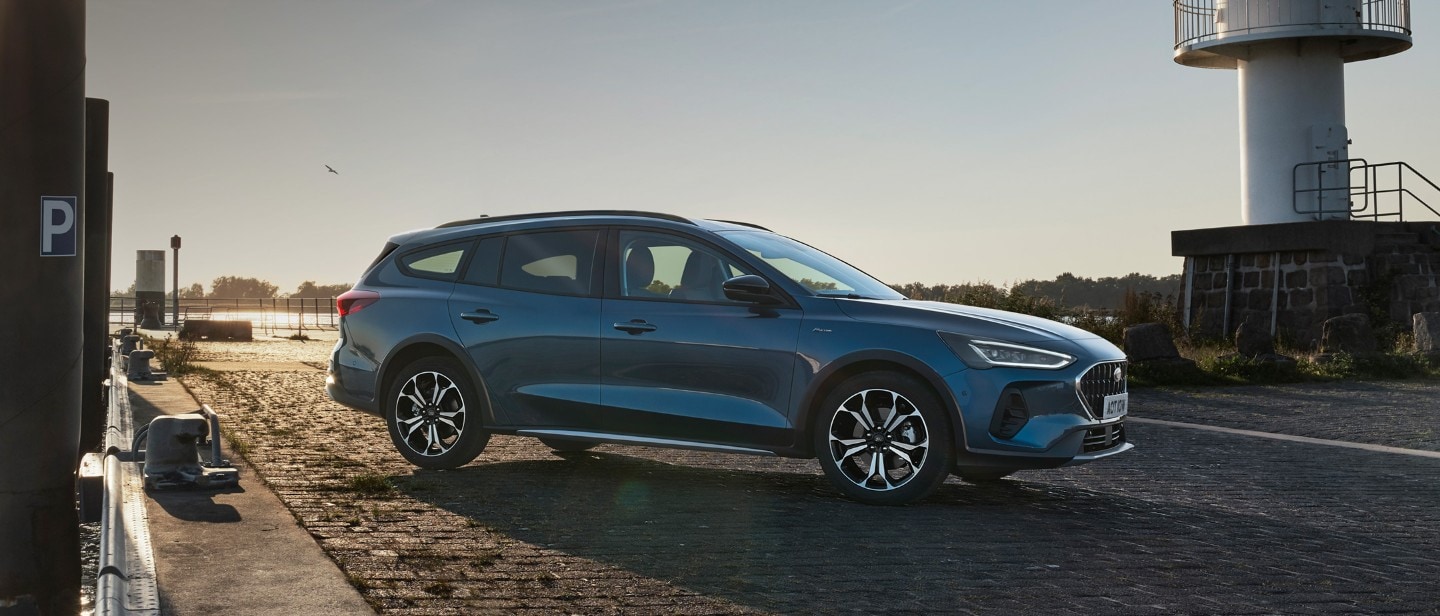 Ford Focus in Blau. Frontansicht, fährt durch verschneite Landschaft