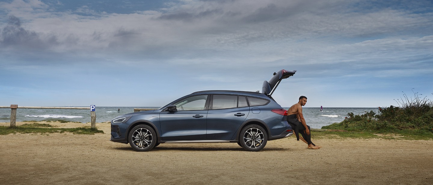 Ford Focus in Blau. Seitenansicht, parkt am Strand