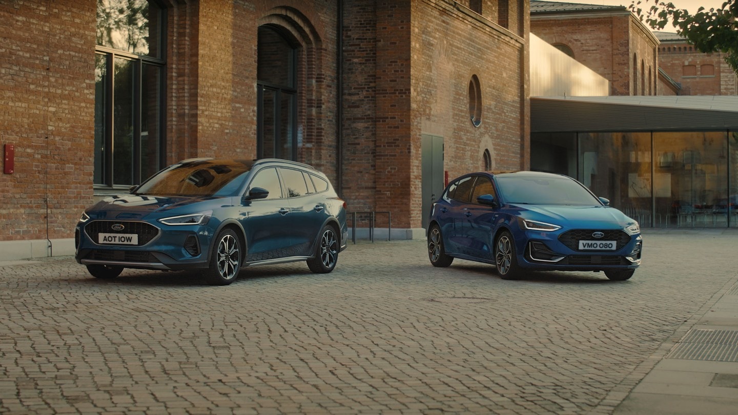 Ford Focus in Blau. Frontansicht, vor einem Ziegelsteingebäude geparkt