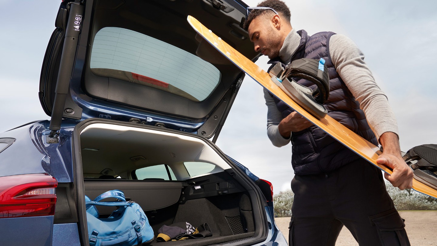 Ford Focus in Blau. Heckansicht mit geöffneter sensorgesteuerten Heckklappe.