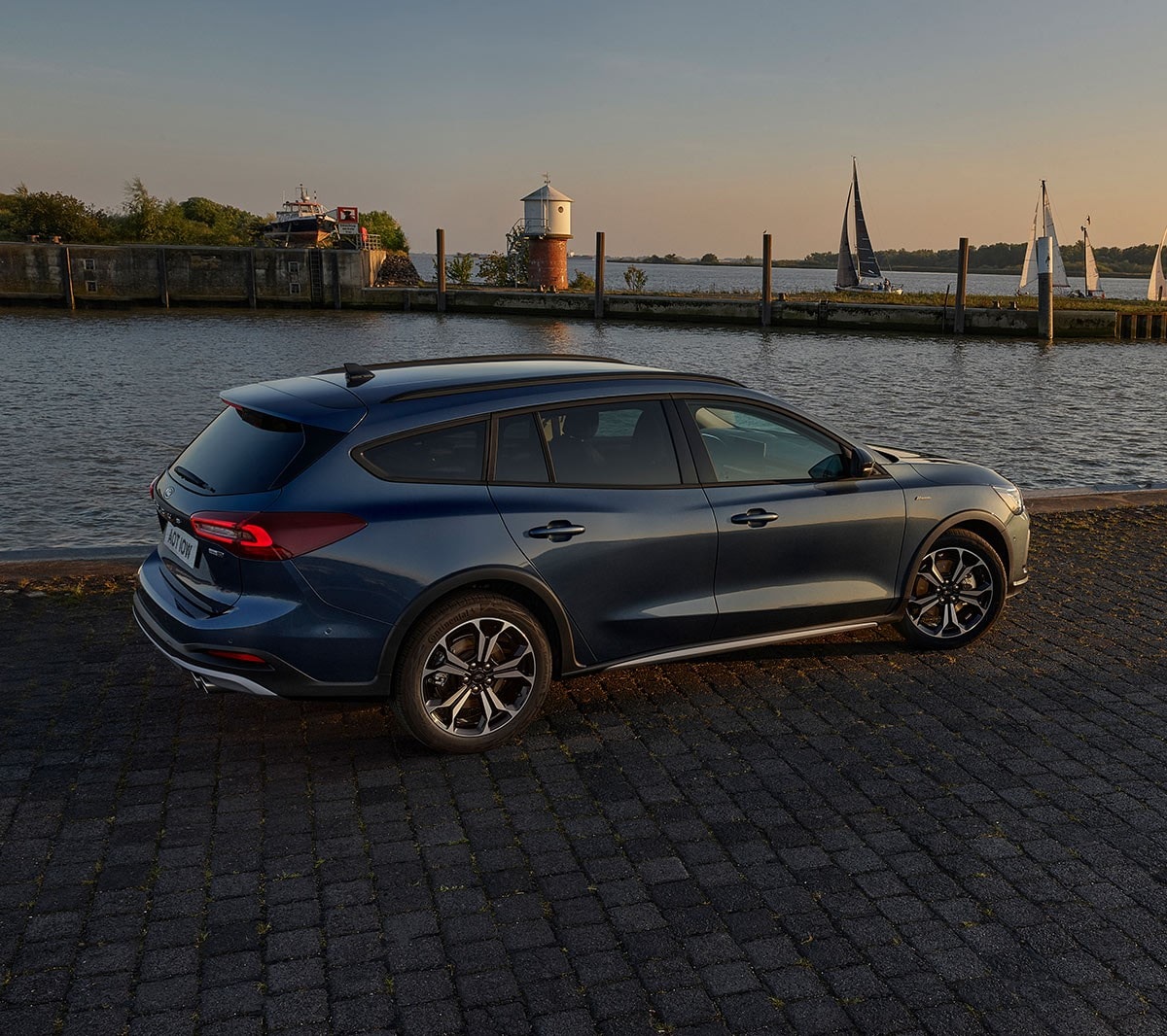 Ford Focus Active in Blau. Seitenansicht, vor einem See parkend.