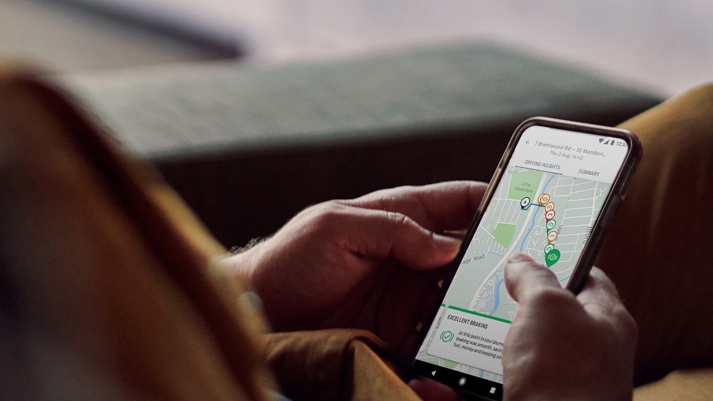 Detailansicht Hand mit Smartphone und FordPass App