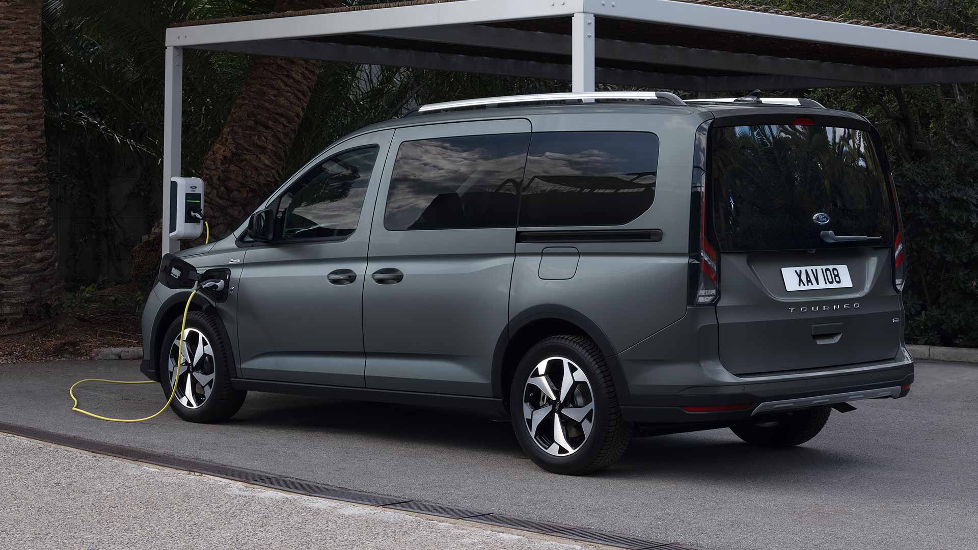 Ford Tourneo Connect PHEV in Grau. Dreiviertelansicht, angeschlossen an einer Ladestation.