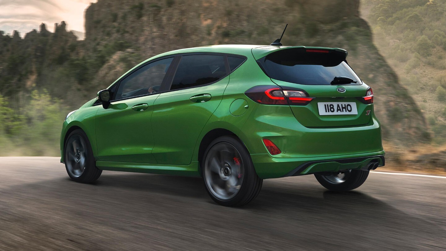 Ford Fiesta ST in Grün. Dreiviertelansicht, auf Straße in den Bergen fahrend.
