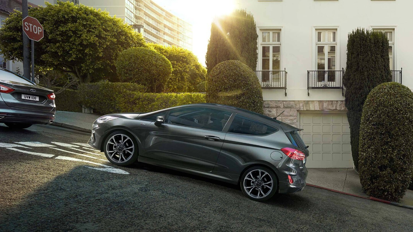 Ford Fiesta ST in Blau. Seitenansicht, bei Berganfahrt in der Stadt.