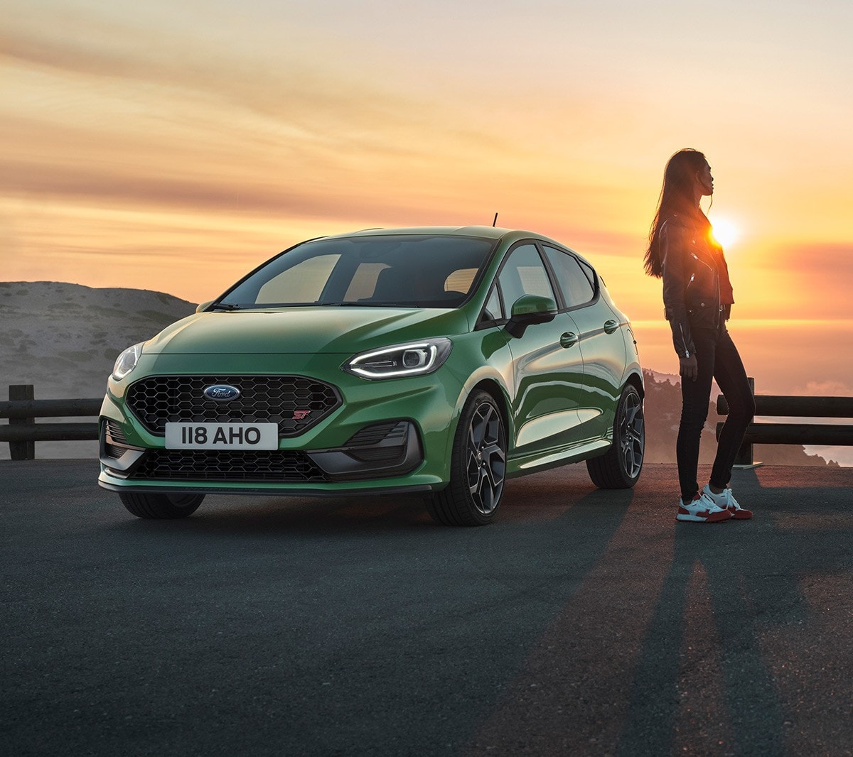 Fiesta ST in Grün. Dreiviertelansicht, Frau betrachtet den Sonnenuntergang.