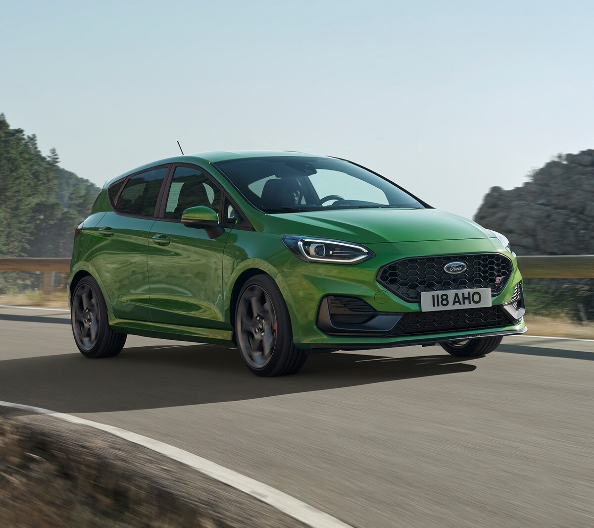 Ford Fiesta ST in Grün. Dreiviertelansicht, auf Straße in den Bergen fahrend.