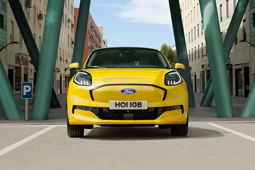 Ford Puma Gen-E in Gelb  fährt auf einer Straße durch die Stadt.
