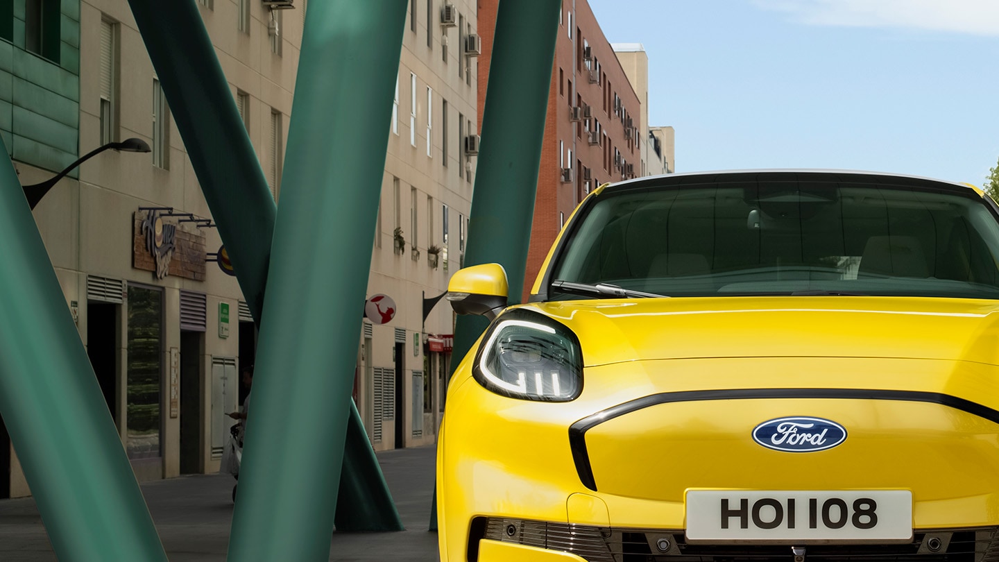 Ford Puma Gen-E in Gelb. Frontansicht, fahrend auf einer Straße.