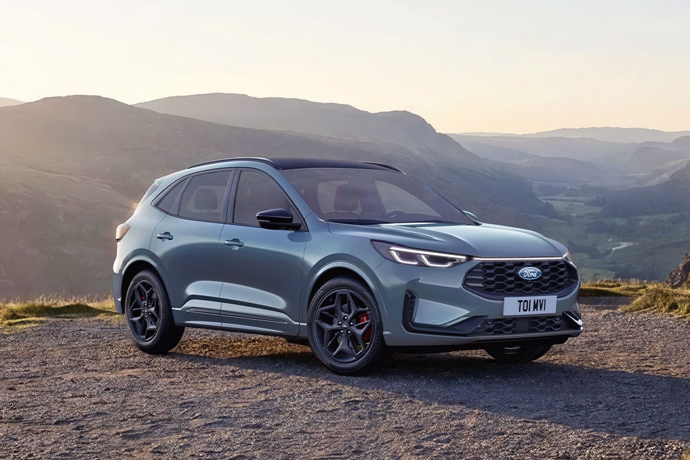 Ein blauer Ford Kuga parkt bei Sonnenuntergang auf einer Schotterstraße.