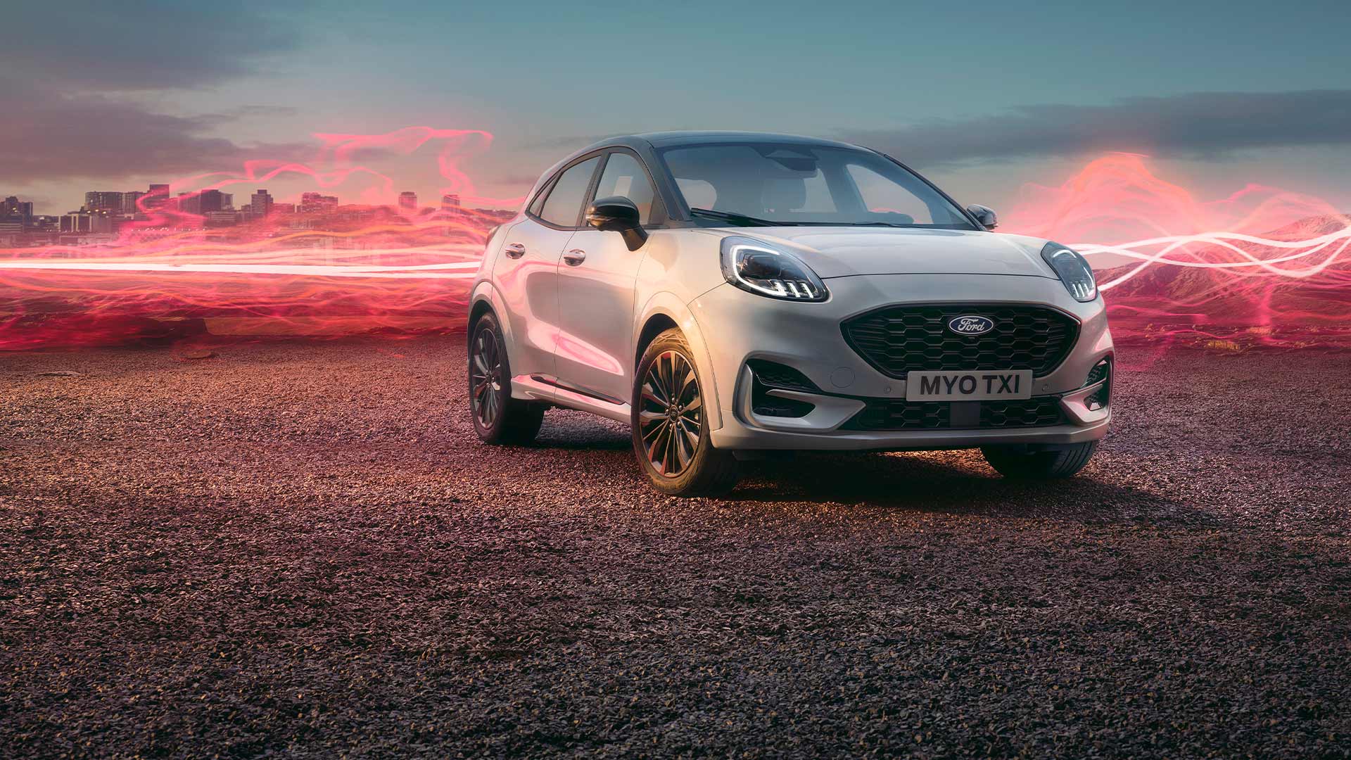 Ford Puma Sound Edition in Weiß. Dreiviertelansicht, parkend mit roter Schallwellengrafik im Hintergrund.