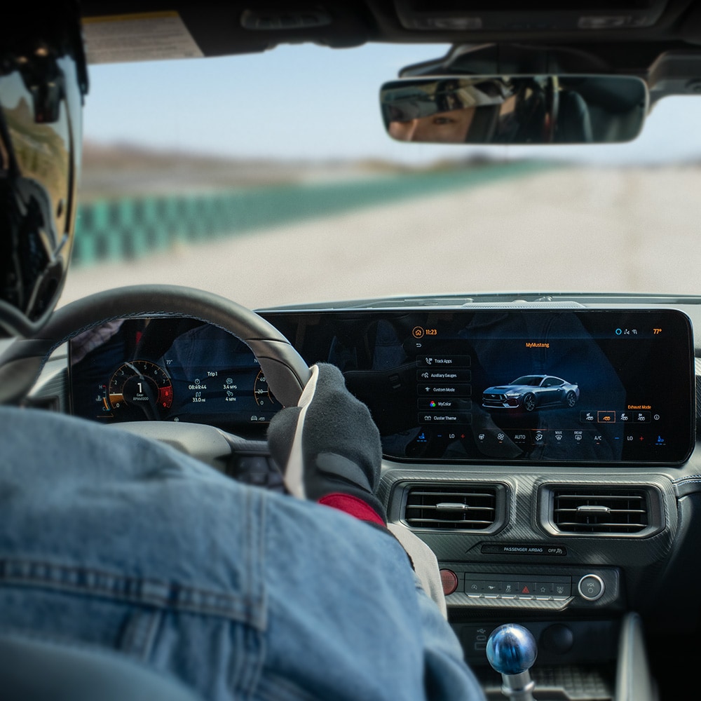 Ford Mustang Innenraum. Ansicht auf Instrumententafel. Person sitzt im Fahrersitz.
