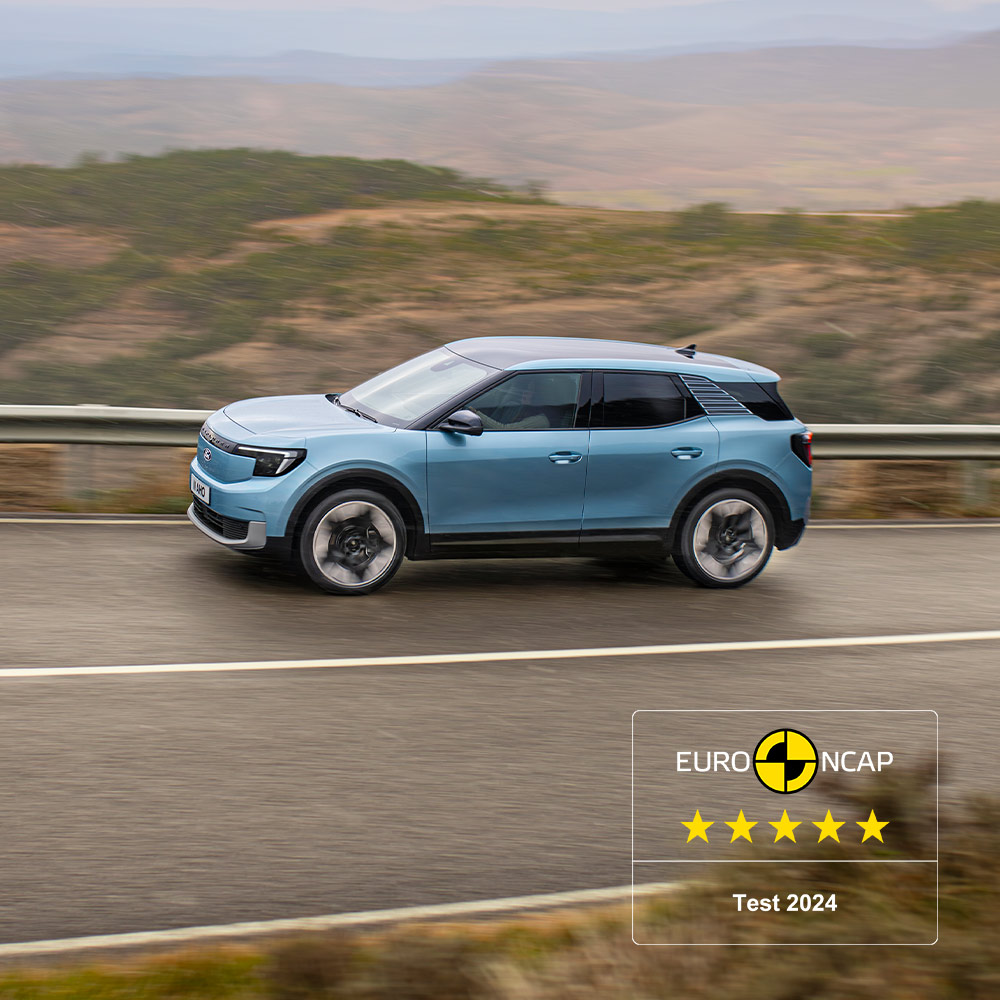 Ford Explorer in Blau. Seitenansicht, auf einer Autobahn mit Wüstenlandschaft in Hintergrund. NCAP-Logo in der rechten unteren Ecke des Bilds.