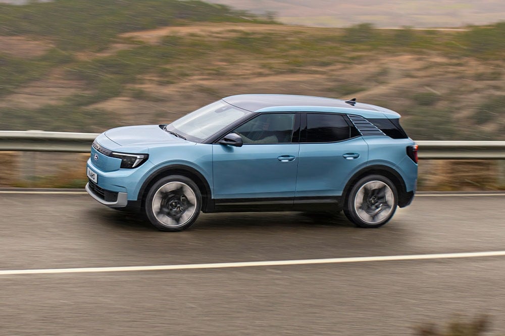 Ford Explorer in Blau. Seitenansicht, auf einer Autobahn mit Wüstenlandschaft in Hintergrund. NCAP-Logo in der rechten unteren Ecke des Bilds.