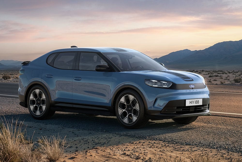 Ford Capri Collection in Blau. Dreiviertelansicht, fährt auf einer felsigen Bergstraße.