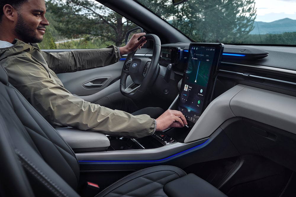Ford Explorer Innenraum. Eine Person sitzt in dem Ford Familien SUV und bedient den Touchscreen.