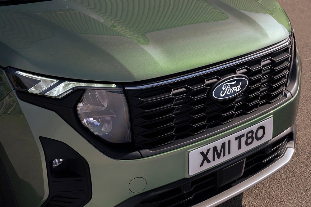 Ford Tourneo Courier Minivan in Grün. Detailansicht der Frontpartie und des Scheinwerfers.