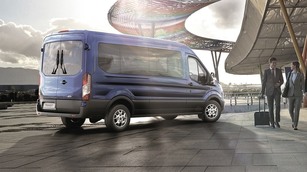 Ford Transit Bus in Blau. Heckansicht, parkt vor Flughafen