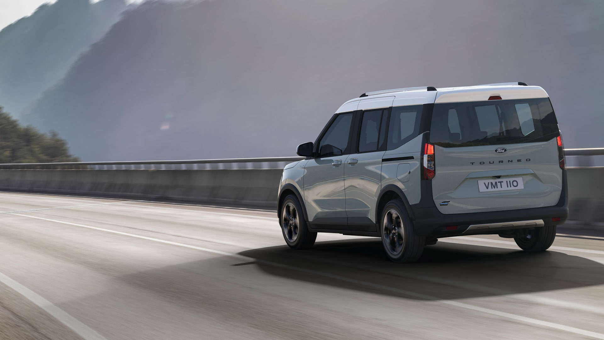 Ford E-Tourneo Courier in Silber. Dreiviertelansicht, fahrend auf einer Autobahn.