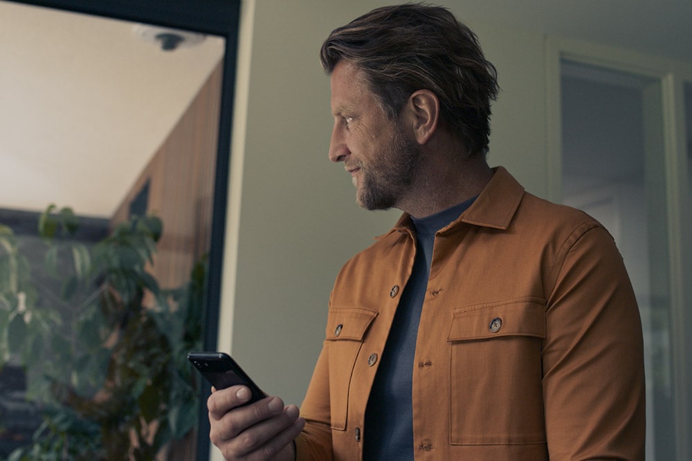 Mann hält Smartphone in der Hand.