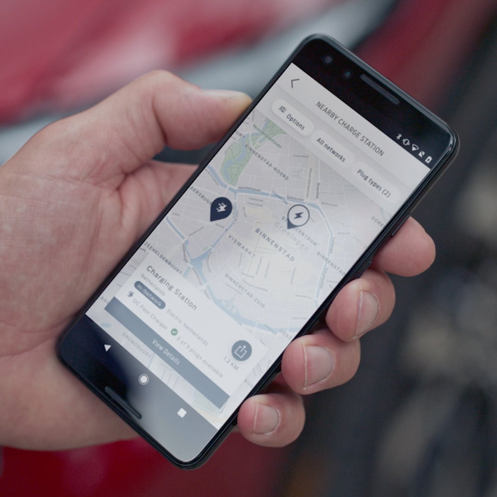 Person hält Smartphone mit geöffneter FordPass App in der Hand.