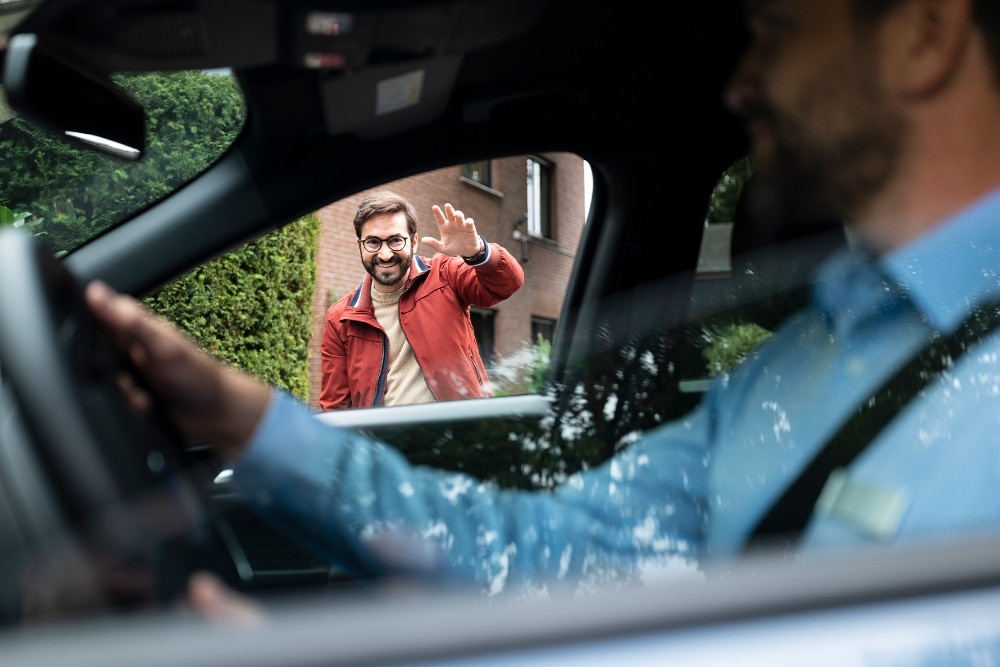 Ein Ford-Servicemitarbeiter mit Maske übergibt ein Fahrzeug.