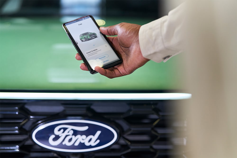 Mann sieht sich auf einem Smartphone die Ford App an