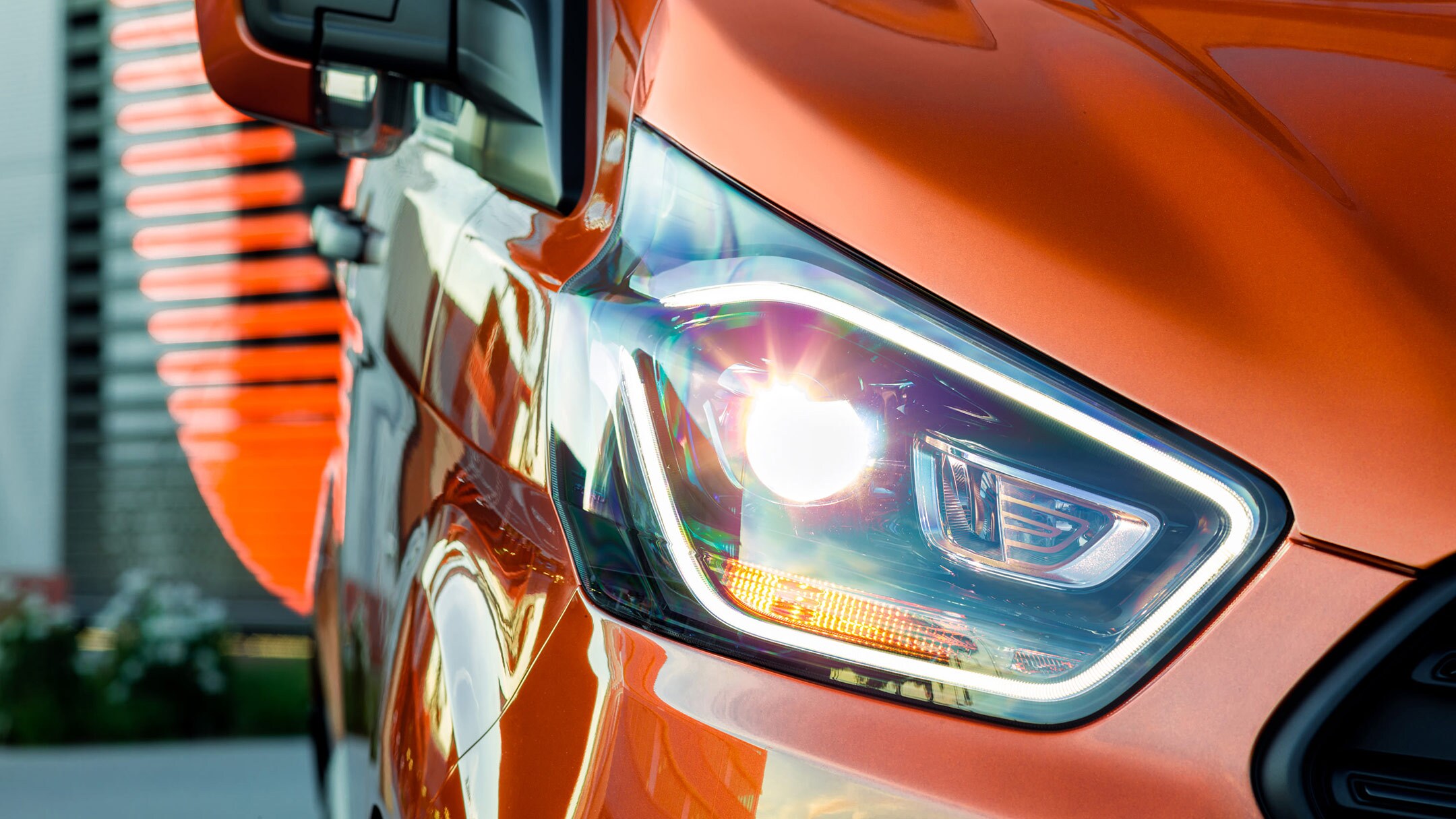 Ford Transit Custom in Orange. Ausschnitt LED-Tagfahrlicht im Detail