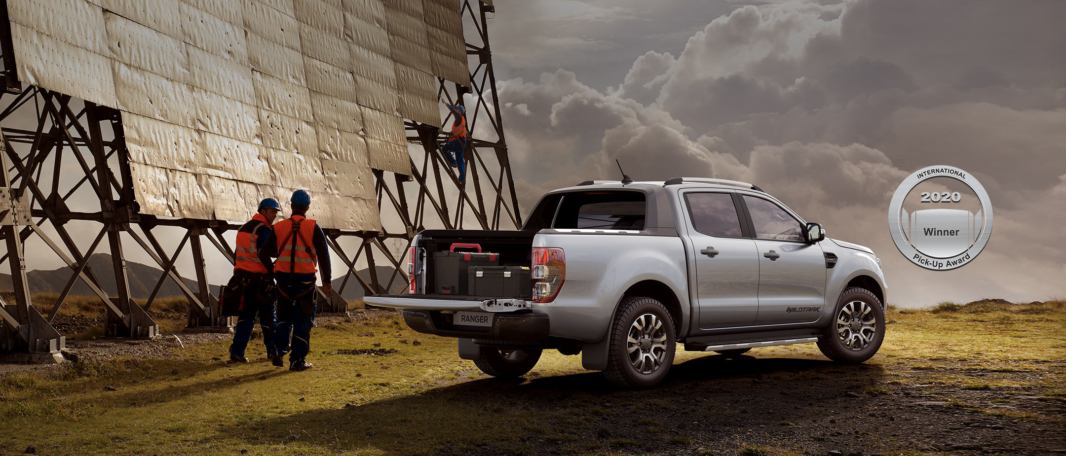 Ford Ranger Silber ¾-Seitenansicht beladen parkt auf Wiese neben Solaranlage