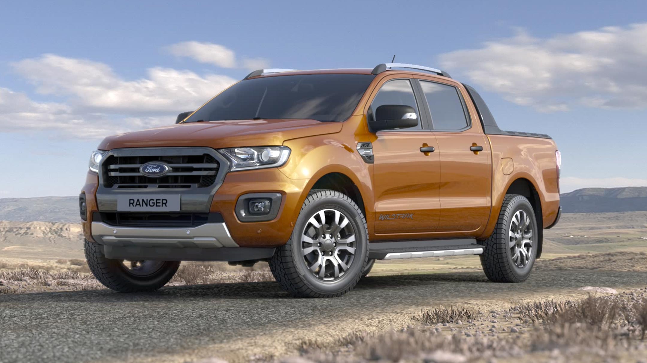 Ford Ranger in Orange. Dreiviertelansicht, steht auf einem felsigen Untergrund