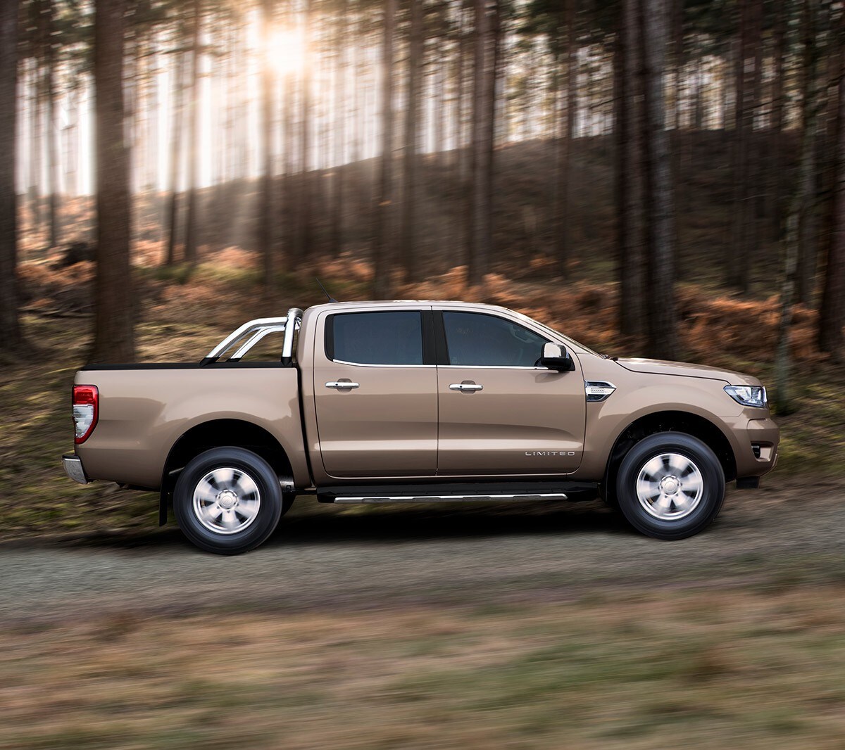 Ford Ranger Limited in Silber. Seitenansicht, fahrend auf einer Forststraße
