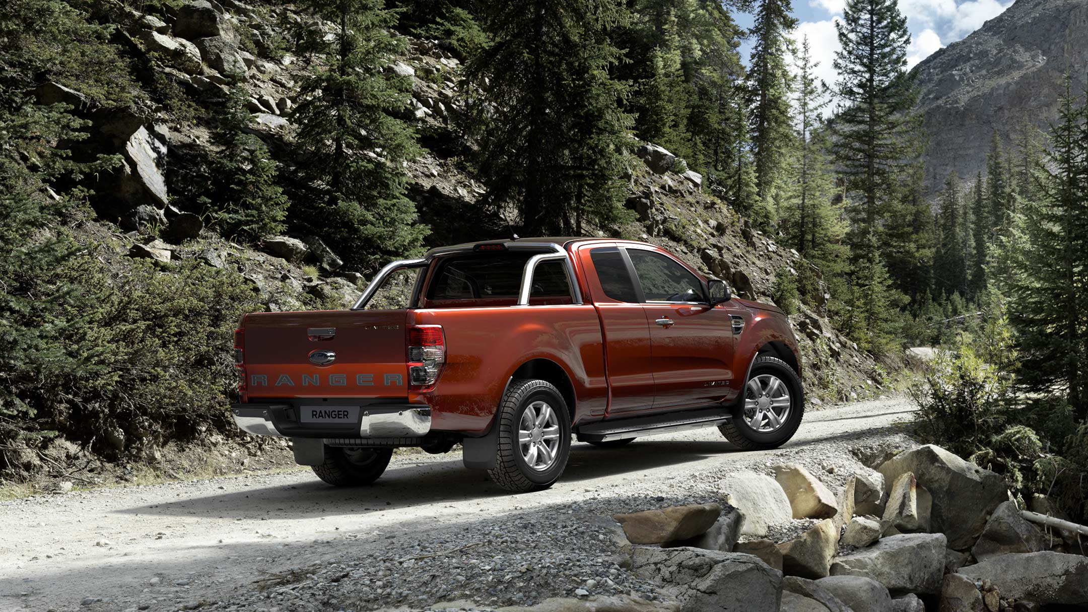 Ford Ranger in Rot. Dreiviertelansicht, parkend auf einem unbefestigtem Weg im Gebirge