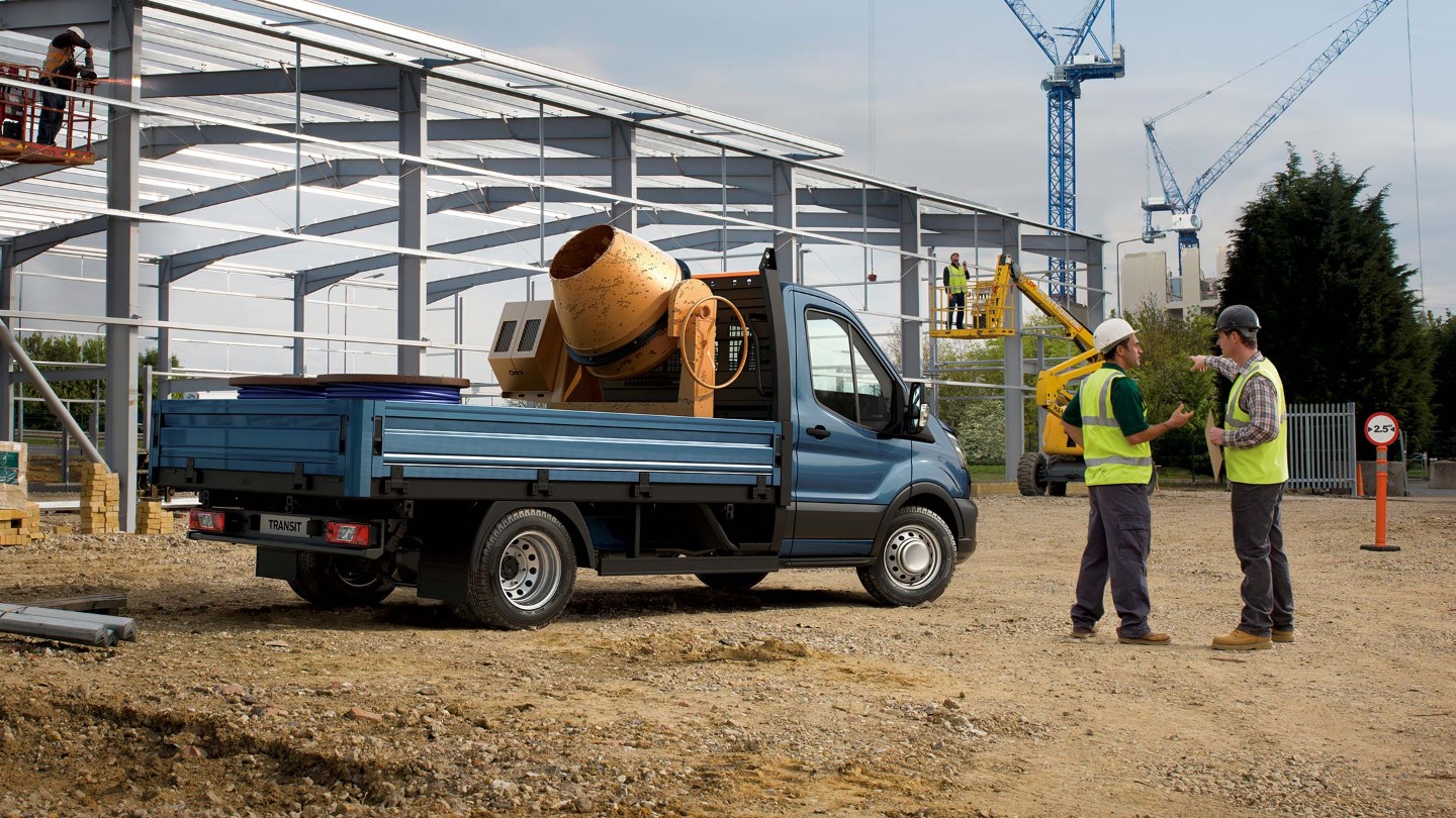 Ford Transit Fahrgestell in Blau. Seitenansicht, beladen auf einer Baustelle