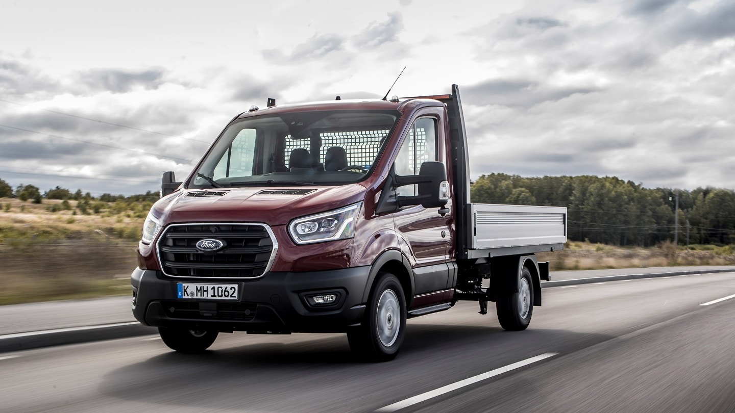 Ford Transit Pritschenwagen in Rot. Frontansicht, in Bewegung auf Landstraße