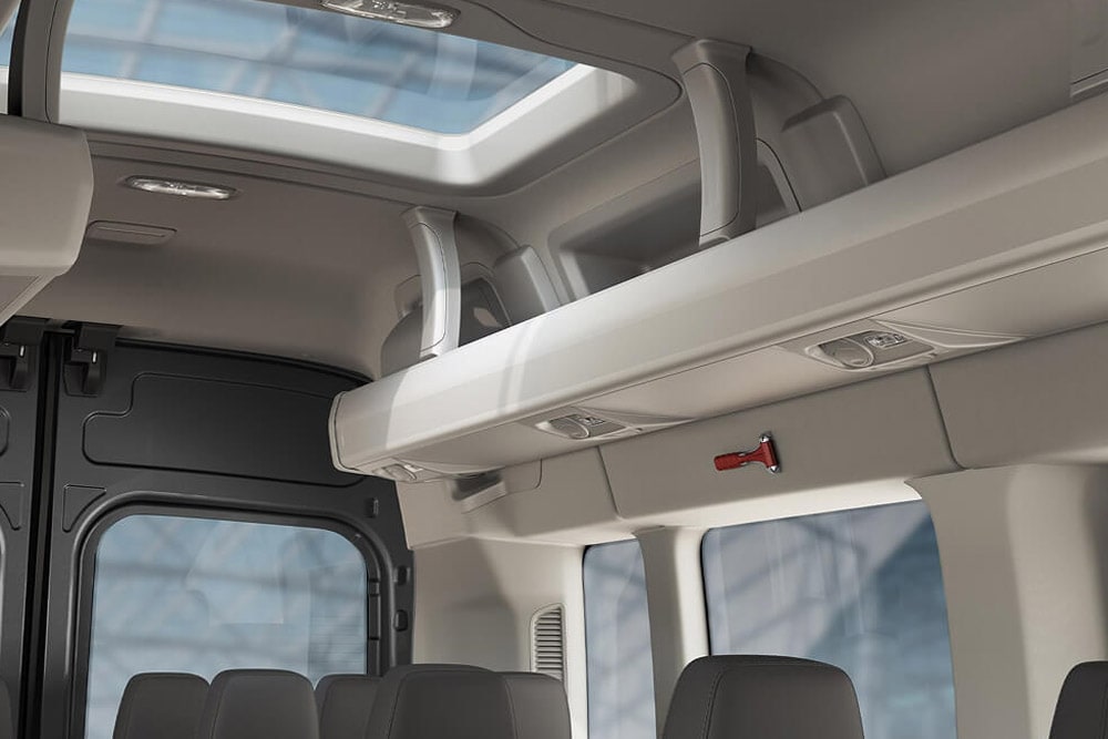 Ford Transit Bus Innenraum. Ausschnitt des Fahrgastbereichs mit Dachfenster und Ablagemöglichkeit.