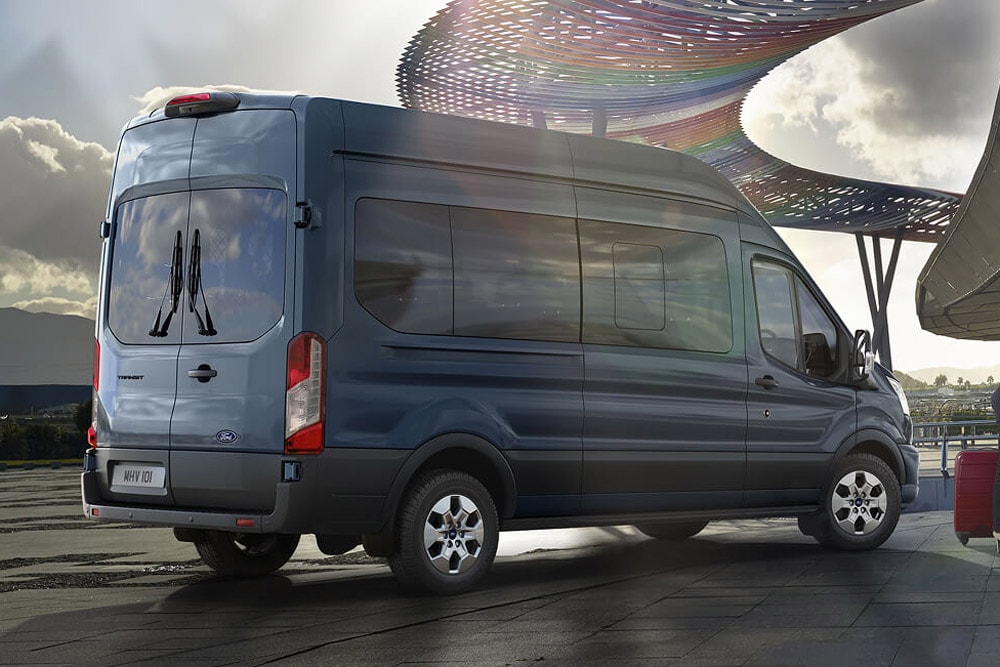 Ford Transit Bus in Blau. Heckansicht, parkt vor Flughafen.