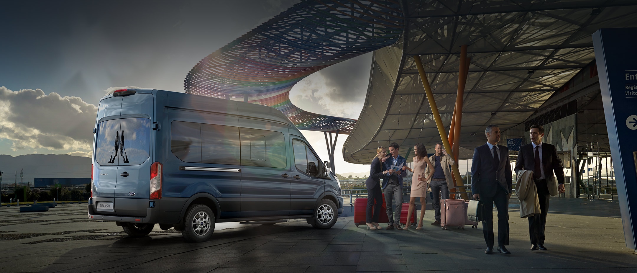 Ford Transit Bus in Blau. Heckansicht, parkt vor Flughafen.