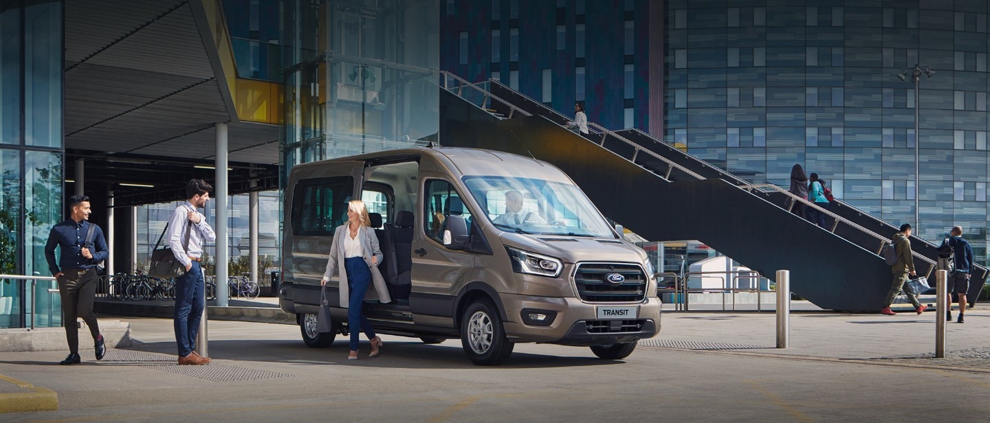 All New Ford Transit Minibus parked outside glass building